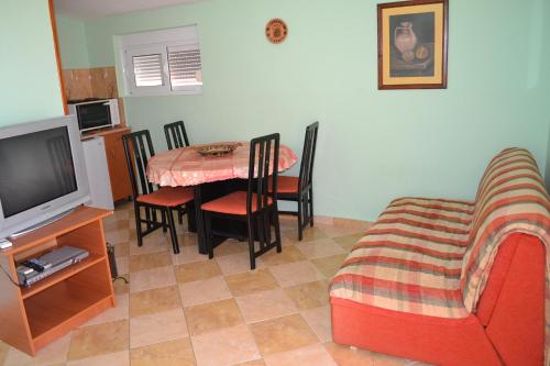 a living room with a table and chairs and a television at Apartments Milosevic in Bar