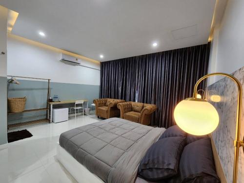 a bedroom with a bed and a living room at PPhouse Boutique House Phuket Town in Ban Bang Khu
