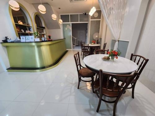 a dining room with a white table and chairs at PPhouse Boutique House Phuket Town in Ban Bang Khu