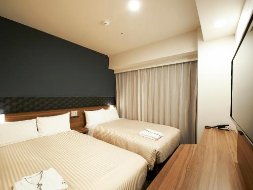 Voodi või voodid majutusasutuse Sotetsu Fresa Inn Kitahama toas