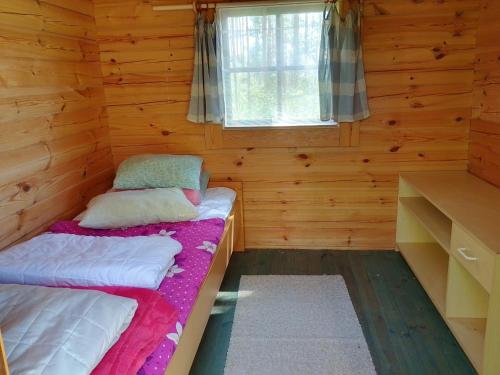 a room with two beds in a log cabin at Kalliomökki in Puumala