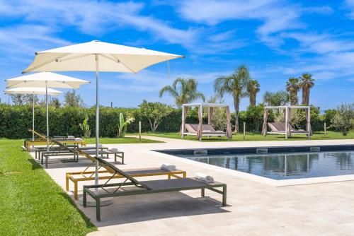 a group of chairs and umbrellas next to a pool at Nèroli Bio Relais in Catania
