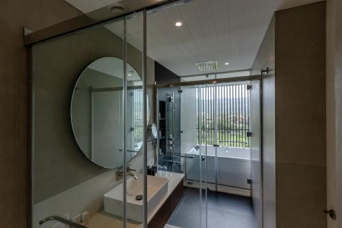 a bathroom with a mirror and a tub and a sink at Radisson Resort and Spa Lonavala in Lonavala