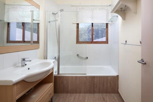 La salle de bains est pourvue d'une baignoire, d'un lavabo et d'une douche. dans l'établissement Casa Rural el Cerrillo, à Cómpeta
