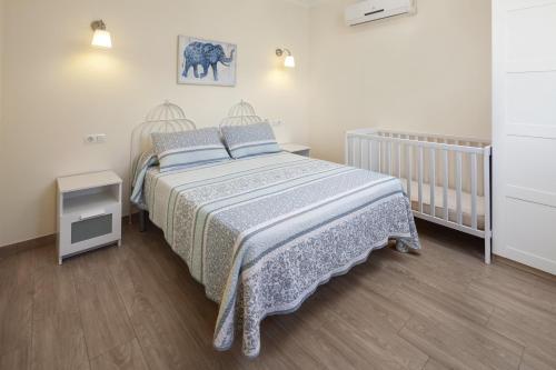 a bedroom with a bed and a crib in it at Casa Rural el Cerrillo in Cómpeta