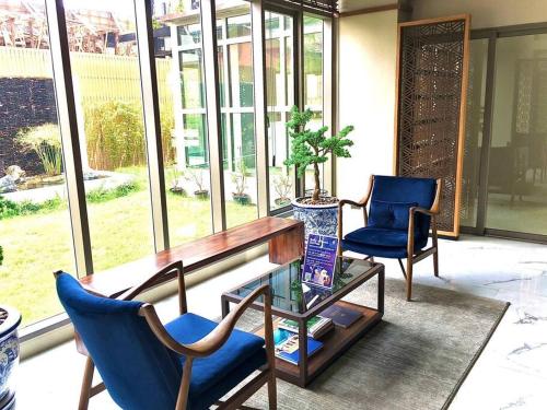 a room with two blue chairs and a wooden desk and a table at Lovely condo with swimming pool. in Bang Sare