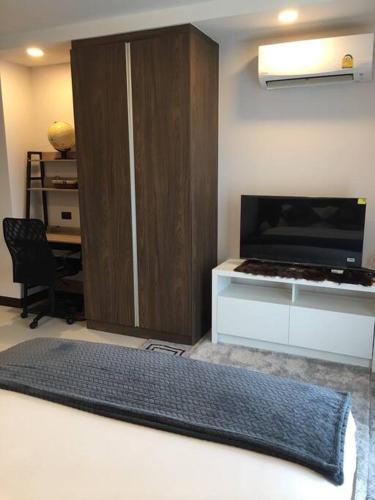 a living room with a desk and a rug at Lovely condo with swimming pool. in Bang Sare
