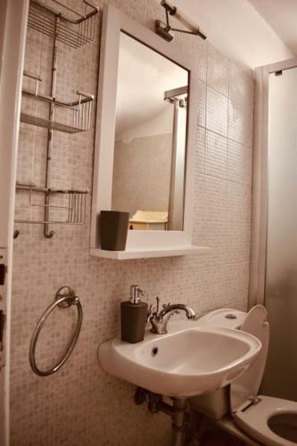 a bathroom with a sink and a toilet and a mirror at Serifos Rock Villa in Serifos Chora