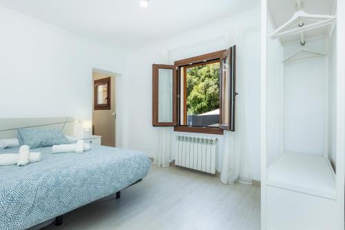 Habitación blanca con cama y ventana en Sestel, en Capdepera