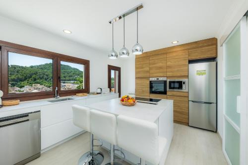 a kitchen with a white counter top and wooden cabinets at Sestel in Capdepera