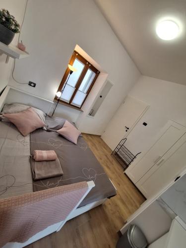 a large bed in a room with a window at Apartma Koper2 with parking in Koper