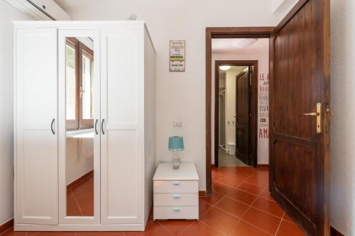 un couloir avec une porte et une commode avec une lampe. dans l'établissement Villa Princy, à Torre delle Stelle