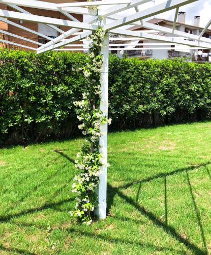 a white pergola with flowers on it in a yard at STRAPALU' in Fondi