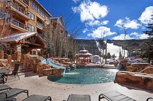 einem Resortpool mit Wasserfall und Rutsche in der Unterkunft 8858 The Springs Condo in Keystone