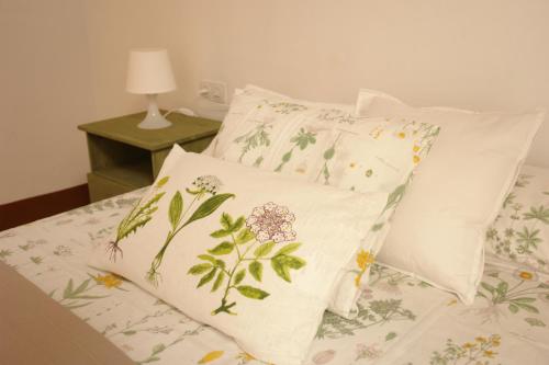 Una cama con dos almohadas con flores. en Hostal Parellades, en Sitges