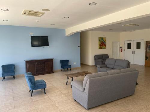 a living room with a couch and chairs and a tv at Protaras Tennis and Country Club in Protaras