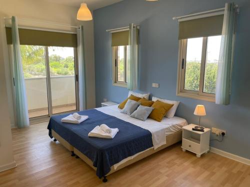 a bedroom with a large bed with two towels on it at Protaras Tennis and Country Club in Protaras