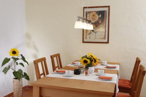 a dining room with a table with sunflowers on it at Ferienwohnungen Holder in Anhausen