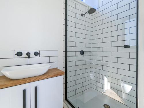 a bathroom with a sink and a glass shower at Glamping Vineyard Getaway with Luxury Amenities in Broke