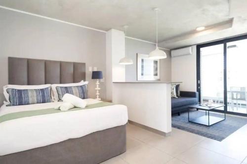 a bedroom with a large bed and a living room at Lux Holiday Apartment Sibaya in Umdloti
