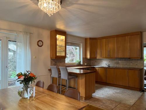 a kitchen with a table and chairs and a vase of flowers at Grand villa with great location! in Gothenburg
