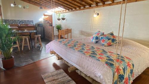 a bedroom with a swing bed and a dining room at Hostería Colibri Aeropuerto in Tababela