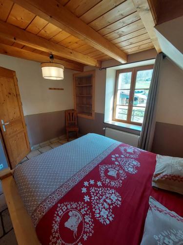 a bedroom with a bed with a red blanket at Equi'val in Le Tholy