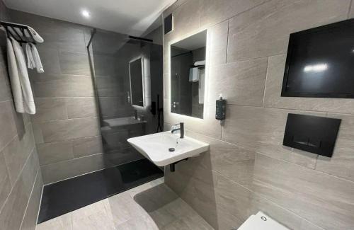 a bathroom with a white sink and a shower at Lydiard Park Hotel & Conference Centre in Swindon