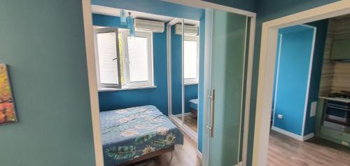 1 dormitorio con paredes azules y 1 cama pequeña en una habitación en Марказ_5, en Tashkent