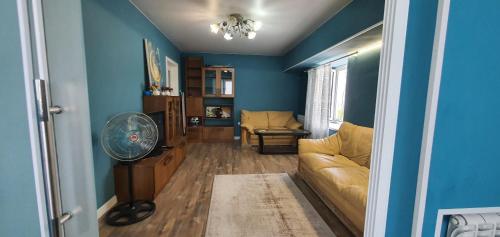 a blue living room with a couch and a fan at Марказ_5 in Tashkent