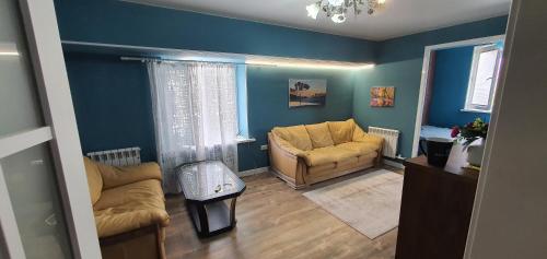 sala de estar con paredes azules y sofá en Марказ_5, en Tashkent