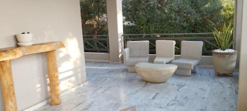 Aghia Marina的住宿－Suite with garden，门廊上设有带椅子和桌子的天井。