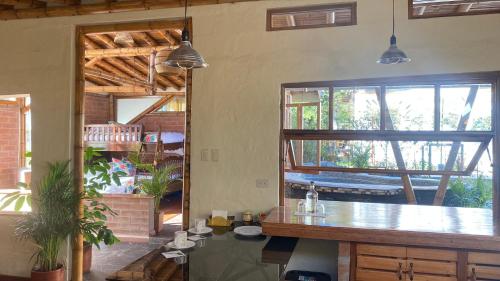 a kitchen with a counter and a large window at Hostería Colibri Aeropuerto in Tababela
