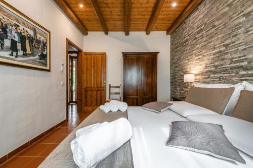 two beds in a room with a brick wall at Casa Suestellas in Teulada