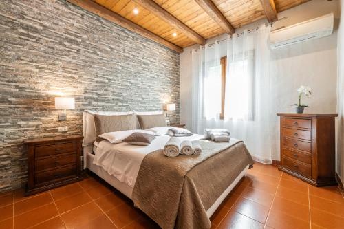 a bedroom with a large bed and a brick wall at Casa Suestellas 