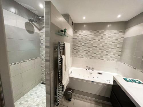 a bathroom with a tub and a sink at Appartement 84m² avec 2 parkings privatifs in Villeneuve-Loubet