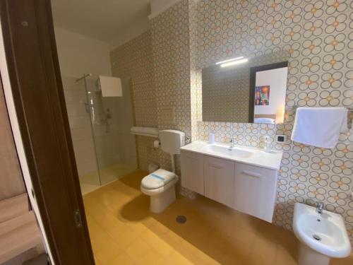 a bathroom with a toilet and a sink and a mirror at affittacamere San Michele in Taranto