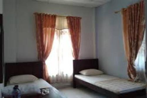 um quarto com 2 camas individuais e uma janela em OYO 92696 Bahagia Homestay Syariah 