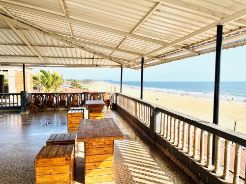 a beach pavilion with benches and a view of the beach at Baga Beach Sunset in Baga