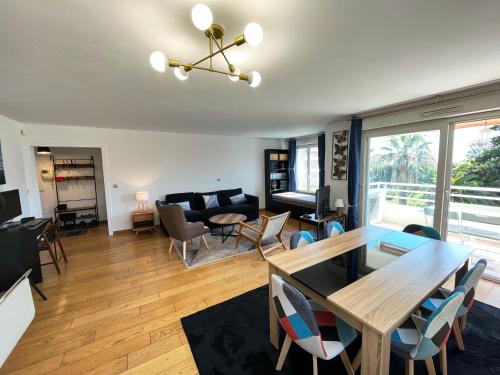 un salon avec une table à manger et un canapé dans l'établissement Appartement 84m² avec 2 parkings privatifs, à Villeneuve-Loubet