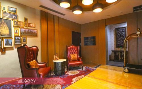 a living room with two chairs and a table at Ramada Suites By Wyndham Solo in Solo