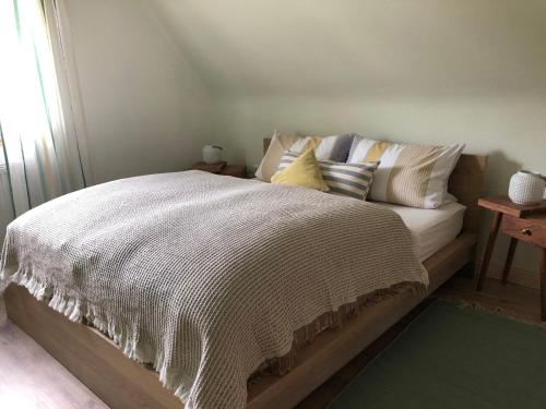 a bed with a white comforter and pillows on it at GartenFerienhaus "AnnaLuise" in Schönau im Schwarzwald