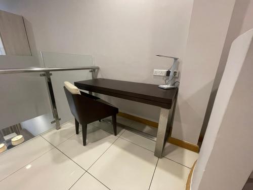 a black desk with a chair in a room at Marina Puteri Harbour Johor by Perfect Host in Nusajaya