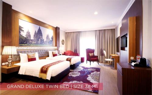 a large hotel room with two beds and a television at Ramada Suites By Wyndham Solo in Solo