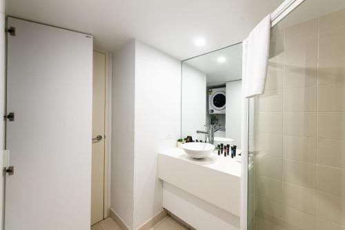ein weißes Badezimmer mit einem Waschbecken und einem Spiegel in der Unterkunft Griffin 175 in Kingston 
