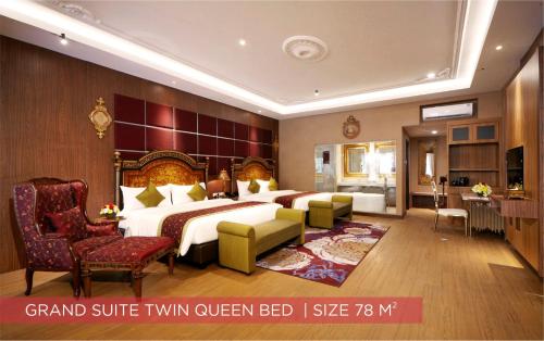 a large hotel room with a bed and a couch at Ramada Suites By Wyndham Solo in Solo