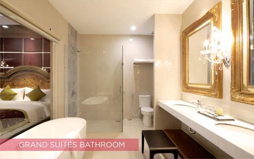 a bathroom with a sink and a shower and a bed at Ramada Suites By Wyndham Solo in Solo