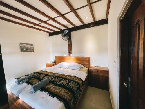Schlafzimmer mit einem großen Bett mit einem Kopfteil aus Holz in der Unterkunft Cool Breeze Authentic Hotel Labuan Bajo Komodo in Labuan Bajo
