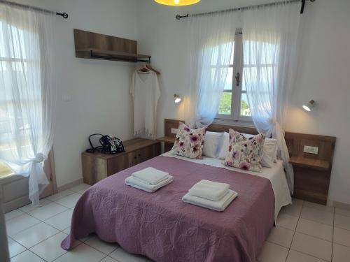 a bedroom with a large bed with towels on it at sivotahomes-Amaya in Sivota