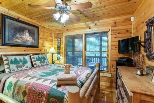 a bedroom with a large bed and a ceiling fan at Mountain Spirit Cabin - Fireplace and Hot Tub in Blue Ridge